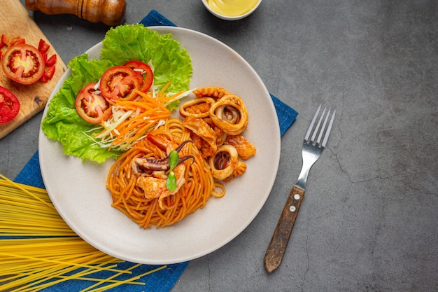 Spaghetti meeresfrüchte mit tomatensauce mit schönen zutaten dekoriert.