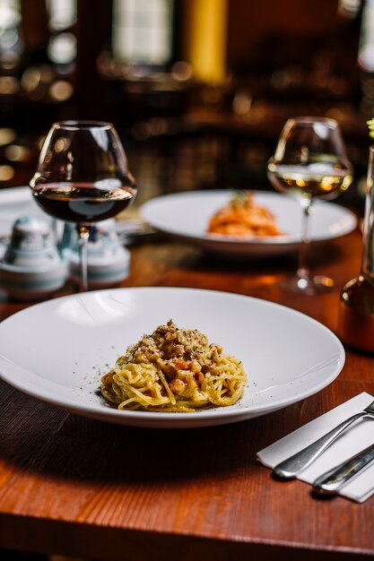 Spaghetti mit Fleisch in cremiger Sauce, garniert mit geriebenem Parmesan