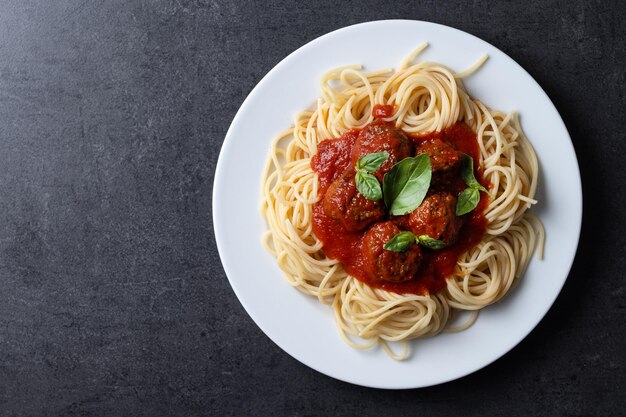 Spaghetti mit Fleischbällen auf schwarzem Hintergrund