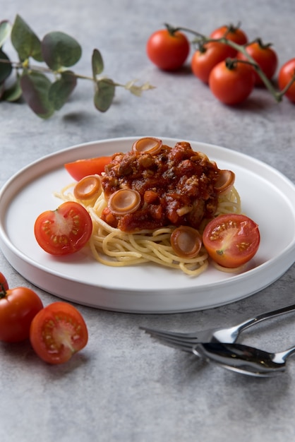 Spaghetti mit Tomatensauce und Wurst im weißen Teller