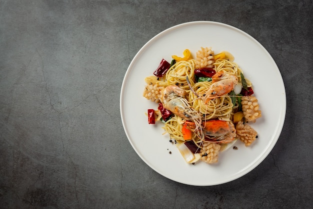 Spaghetti mit würzigen gemischten Meeresfrüchten auf dunklem Hintergrund