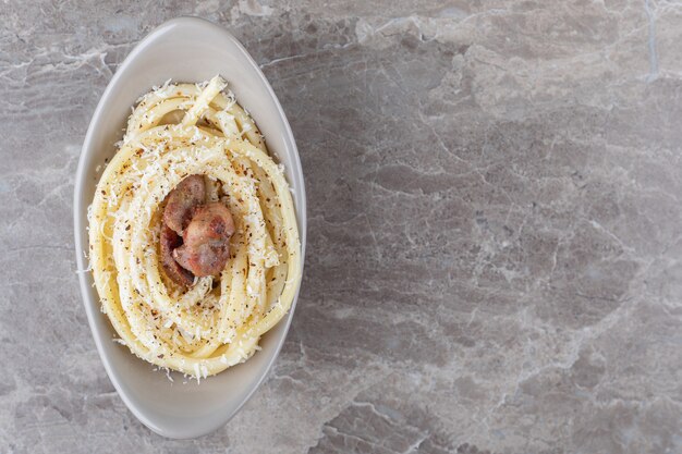 Spaghetti und Fleisch auf der Schüssel auf dem Marmorhintergrund.