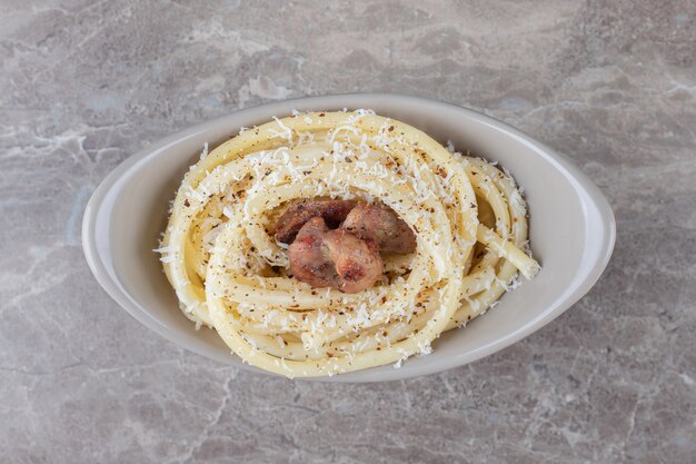 Spaghetti und Fleisch auf der Schüssel, auf der Marmoroberfläche.