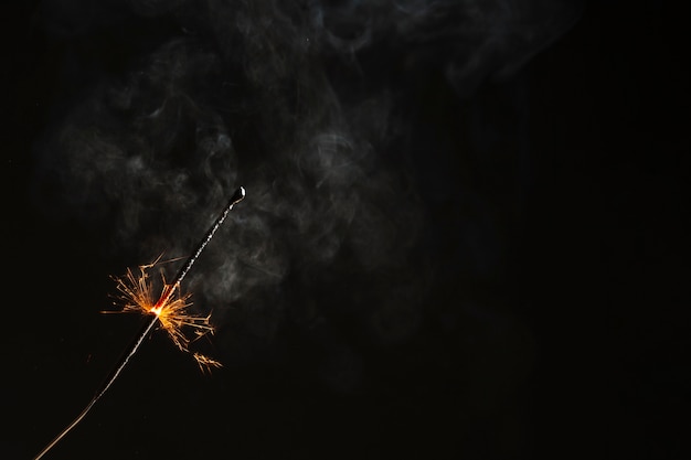 Sparkler, der auf schwarzem Hintergrund flammt