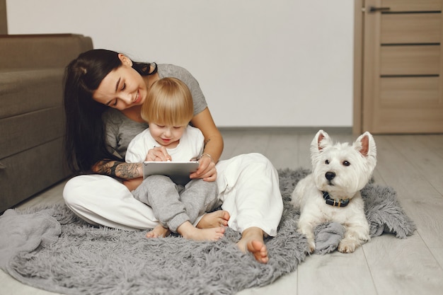 Spaß der Mutter und des kleinen Sohns zu Hause mit Hund