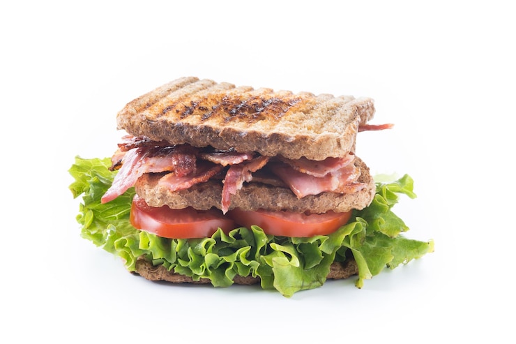 Kostenlose Foto speck-sandwich mit salat und tomaten auf weißem hintergrund