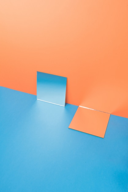 Spiegel auf blauem Tisch lokalisiert auf Orange