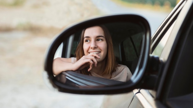 Spiegelbild der Smiley-Frau im Autospiegel