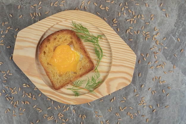 Spiegelei in Toastbrotscheibe auf Holzteller. Hochwertiges Foto