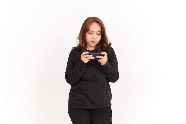 Spielen handy-spiel auf dem smartphone der schönen asiatischen frau mit schwarzem hemd isoliert auf weiss