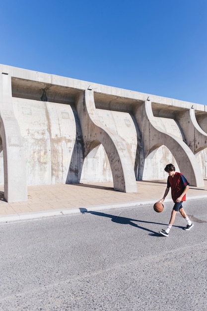 Spieler, der Basketball nahe umgebender Wand spielt