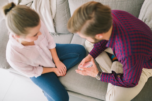 Kostenloses Foto spielkarten der jungen paare auf sofa