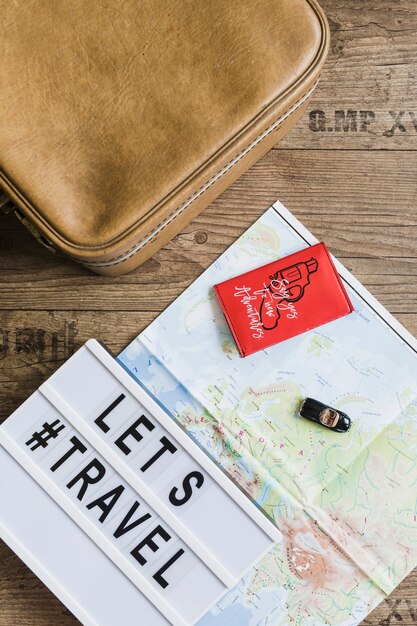Spielzeugauto über der Karte mit lässt Reisetext und -tasche auf Holztisch