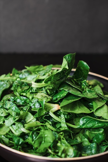 Spinatnahaufnahme in einer Bratpfanne, selektiver Fokus. Konzept zum Kochen von Bio-Lebensmitteln. Frischen grünen Spinat braten