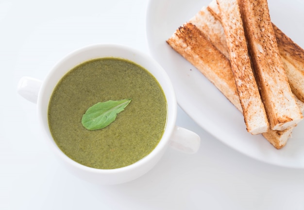 Spinatsuppe mit Spinatblättern und Brot