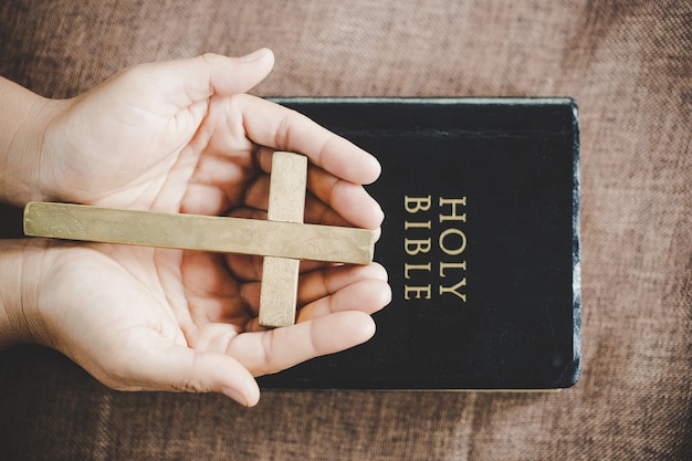 Kostenloses Foto spiritualität und religion, hände falteten sich im gebet auf einer heiligen bibel im kirchenkonzept für glauben.