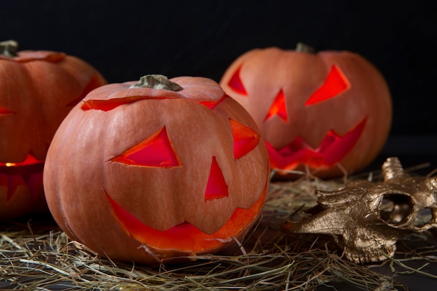 Kostenloses Foto spooky halloween geschnitzte kürbislaterne mit goldenem tierschädel