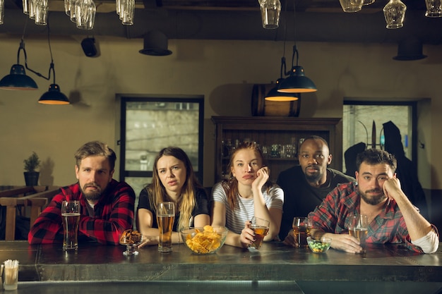 Sportfans jubeln in der Bar, im Pub und trinken Bier, während die Meisterschaft und der Wettbewerb stattfinden