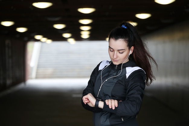 Sportfrau im Freien schaut ihre Armbanduhr