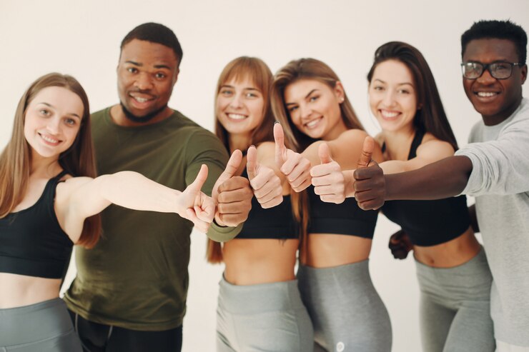 Kostenlose Foto sportgruppe, die auf einer weißen wand steht