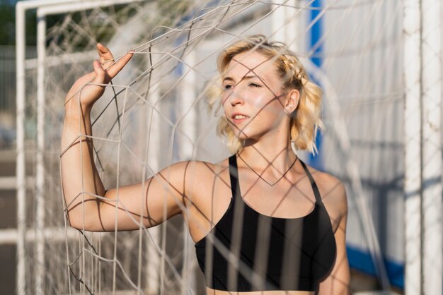 Sportive Frau am Stadion, das Tornetz hält