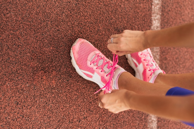 Sportive Frau der Draufsicht bindet Schuhspitzee