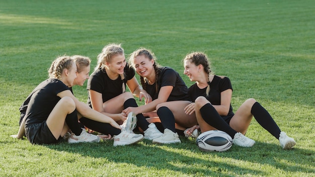 Sportive Frauen, die miteinander auf Gras sprechen