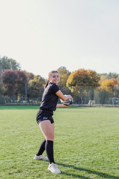 Sportives junges Mädchen, das einen Rugbyball hält