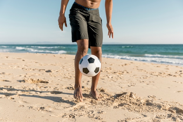 Kostenloses Foto sportler, der ball auf küste schlägt