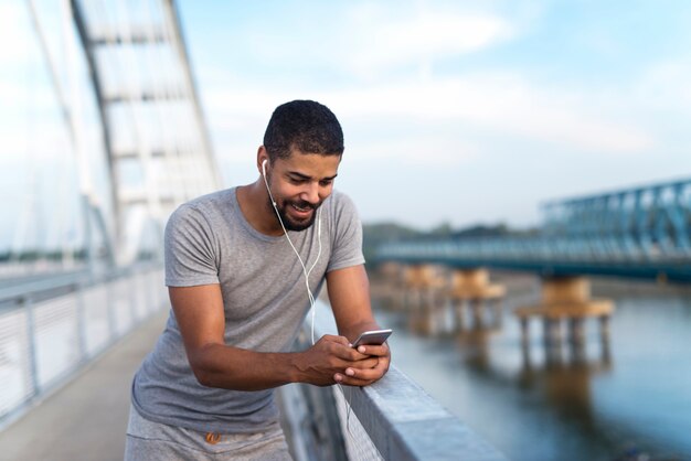 Sportler, der beim Training ein Mobiltelefon verwendet, um die zurückgelegte Strecke zu berechnen