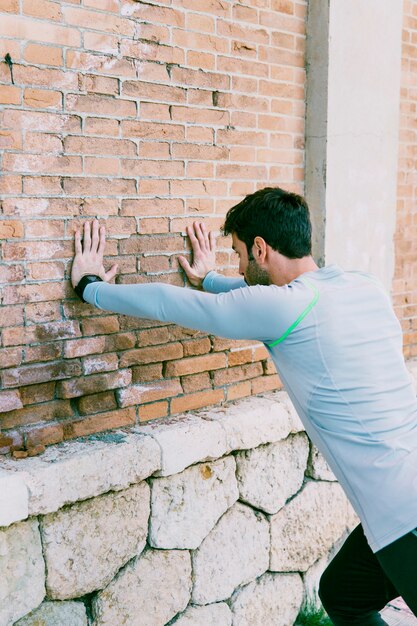 Sportler, der Übungen nahe Wand durchführt