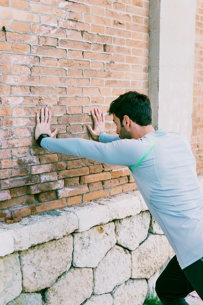 Sportler, der Übungen nahe Wand durchführt