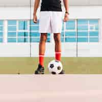 Kostenloses Foto sportler, der mit fußball steht und für spiel am stadion sich vorbereitet