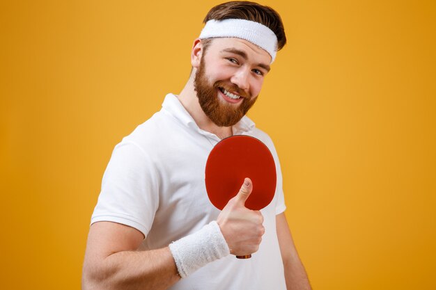 Sportler, der Schläger für Tischtennis hält, der Daumen hoch Geste zeigt.