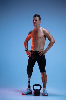 Sportler mit behinderungen oder amputierten isoliert auf blauem studio