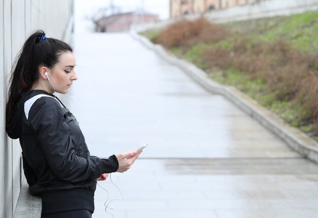 Sportlerin, die ihr Smartphone schaut