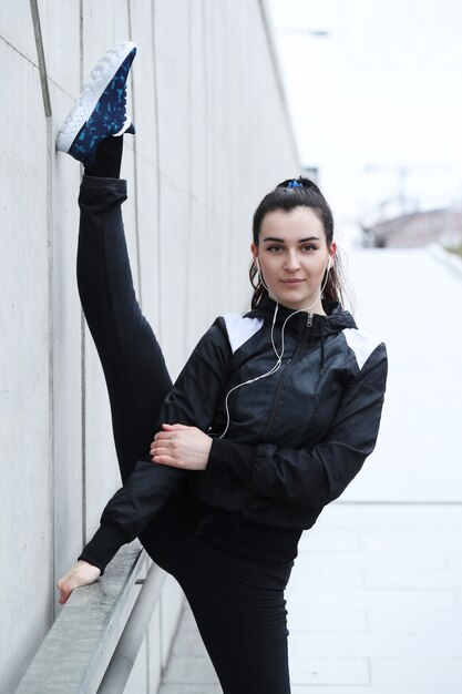 Sportlerin, die sich auf der Straße ausdehnt