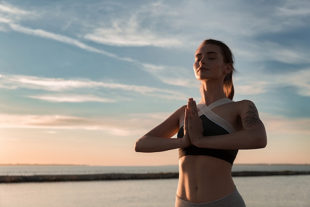 Kostenloses Foto sportlerinnen am strand machen meditationsübungen.