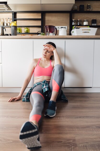 Sportliche Frau des Porträts, die nach dem Training zu Hause ruht