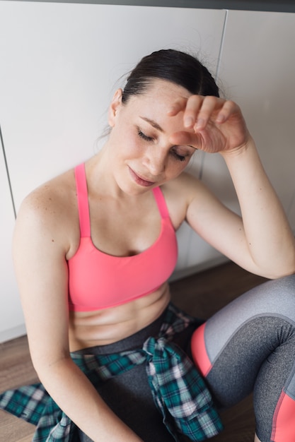 Kostenloses Foto sportliche frau des porträts, die nach dem training zu hause ruht