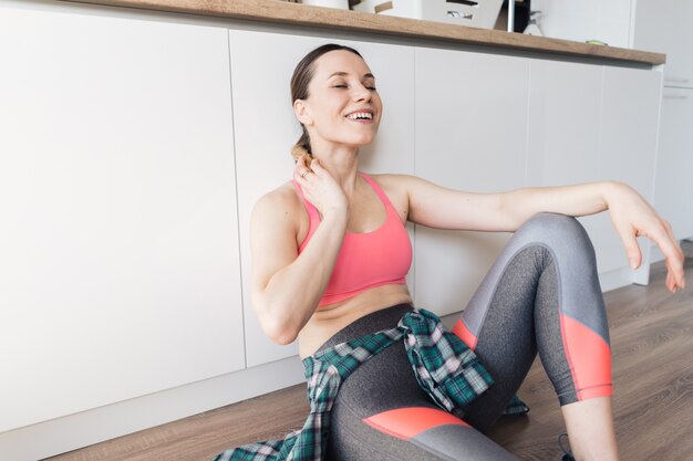 Sportliche Frau des Porträts, die nach dem Training zu Hause ruht