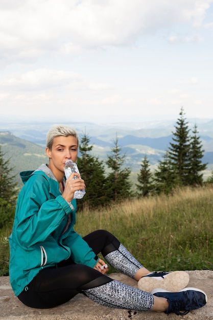 Sportliche Frau, die eine Flasche Wasser hält