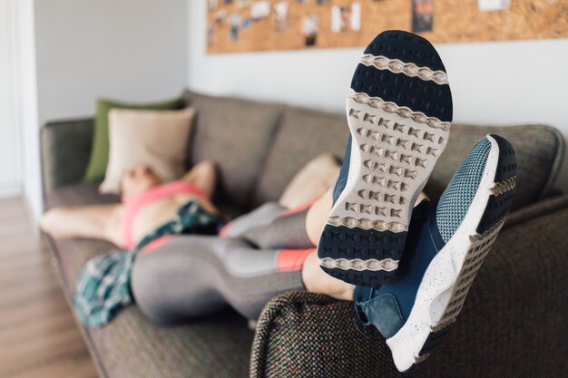 Sportliche Frau, die entspannt auf dem Sofa ruht