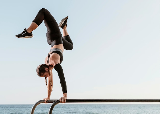 Sportliche Frau, die Fitness-Training draußen am Strand tut