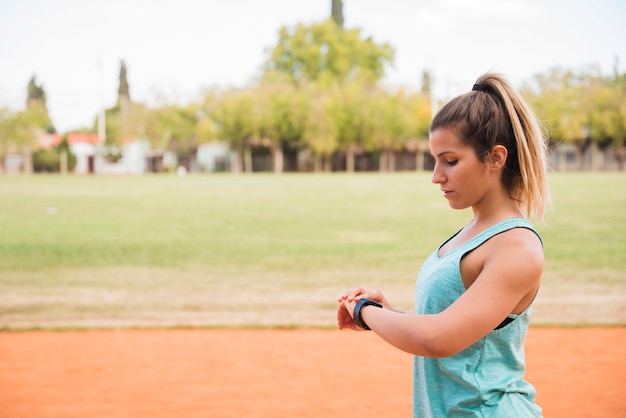 Sportliche Frau, die fitnesstracker betrachtet