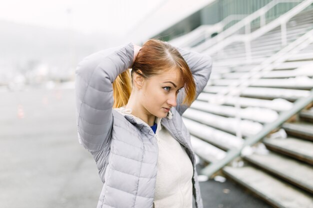 Sportliche Frau, die Pferdeschwanz macht