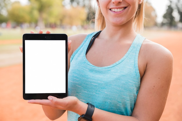 Kostenloses Foto sportliche frau, die tablettenschablone darstellt