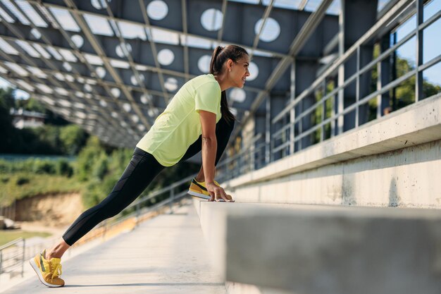 Sportliche Frau, die vor Morgengymnastik ihren Körper dehnt