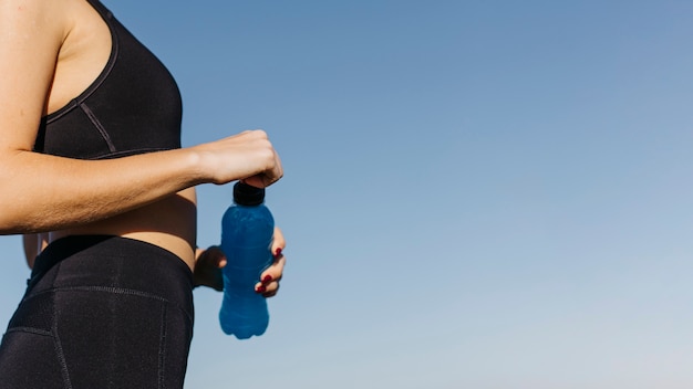 Kostenloses Foto sportliche frau mit plastikflasche am strand