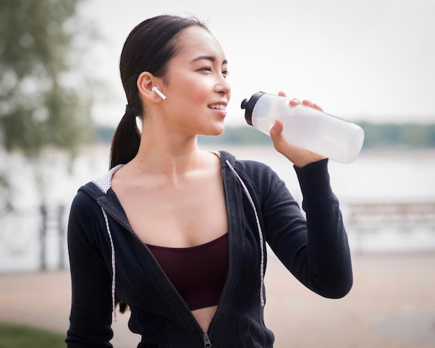 Kostenloses Foto sportliche junge frau, die nach dem training hydratisiert